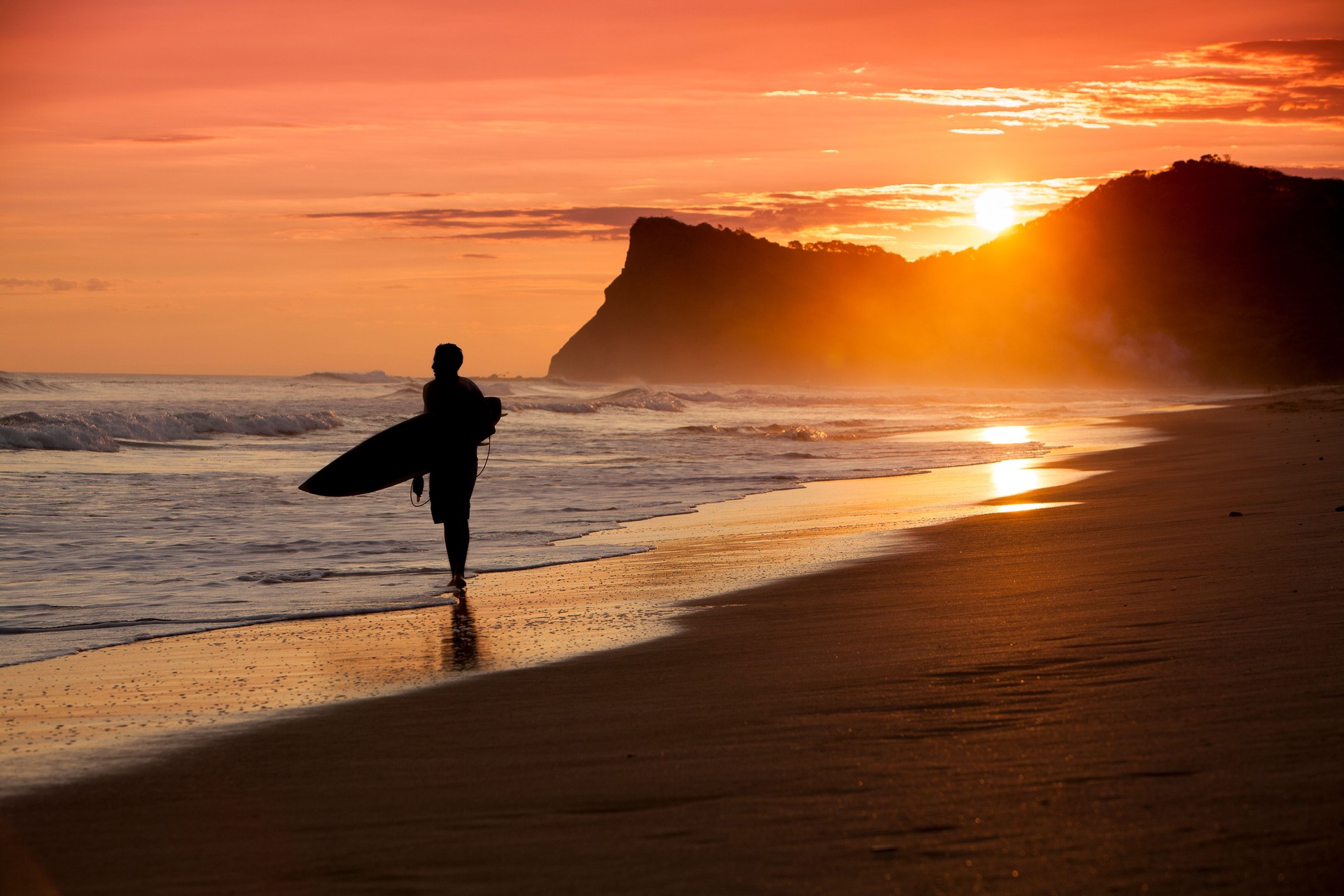 Beach scene in Nicaragua with surfer silhoette at sunset